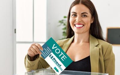 Imagem de uma mulher, sorridente, depositando um voto na urna