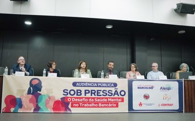 A partir da esquerda, Patrick Maia Merísio Procurador do Trabalho; Maria Maeno,  médica e pesquisadora da Fundacentro; Neiva Ribeiro, presidenta do Seeb-SP; Luiz Cláudio Marcolino, deputado estadual; Maria Leonor Poço Jakobsen, advogada especialista em direitos humanos; e  Ana Lúcia Ramos, secretária-geral da Fetec-CUT/SP Imagem mostra mesa da audiência pública “Sob Pressão: O Desafio da Saúde Mental no Trabalho Bancário” estão lado a lado na mesa, Patrick Maia Merísio Procurador do Trabalho; Maria Maeno,  médica e pesquisadora da Fundacentro; Neiva Ribeiro, presidenta do Seeb-SP; Luiz Cláudio Marcolino, deputado estadual; Maria Leonor Poço Jakobsen, advogada especialista em direitos humanos; e  Ana Lúcia Ramos, secretária-geral da Fetec-CUT/SP.