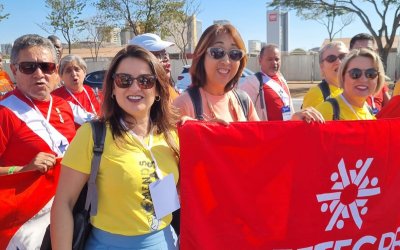 Silmara da Silva, de vermelho, em ato promovido pelo Ministério da Saúde em Brasília Fotografia mostra mulheres, uma de blusa vermelho e outra de amarela, segurando faixa vermelha
